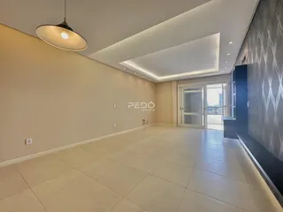 Interior de uma sala ampla com piso de cerâmica e paredes claras.