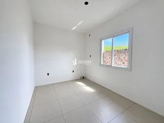Ambiente interno de uma sala com piso de cerâmica e janela.