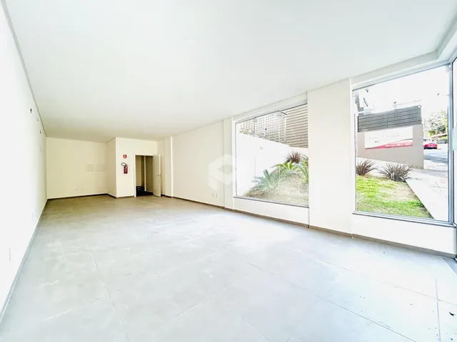 Ambiente interno amplo com paredes brancas e piso claro de uma propriedade em Lajeado.
