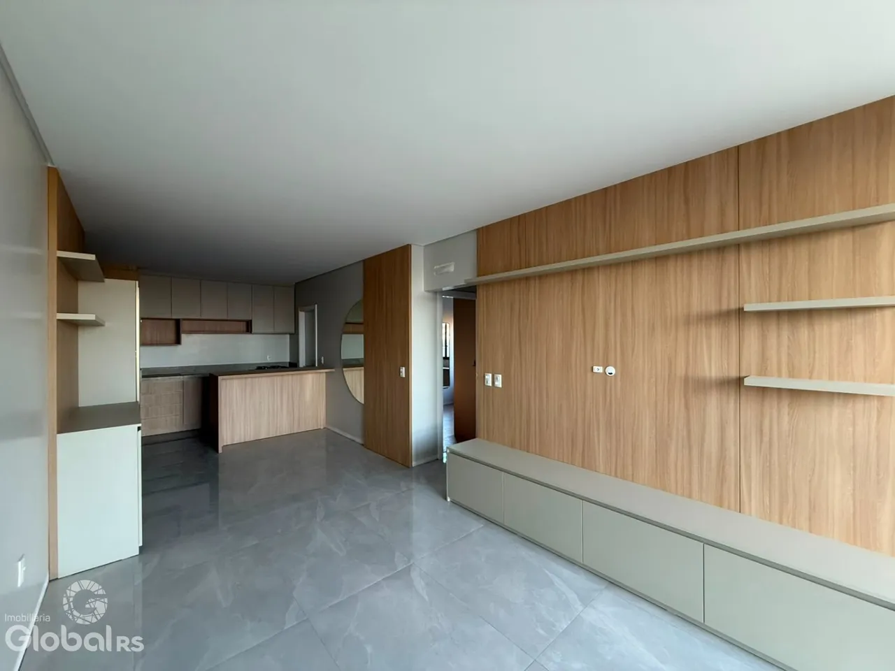 Interior de uma sala de estar moderna com armários de madeira e piso de cerâmica.