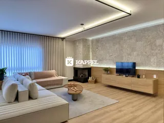 Sala de estar com sofá grande e decoração moderna em um ambiente claro.