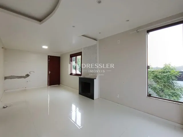 Ambiente interno de uma sala grande com paredes em reforma.