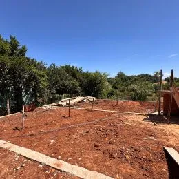 Vista de uma área de terra com vegetação no fundo.