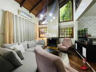 Sala de estar com lareira e grandes janelas em ambiente residencial.
