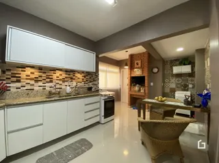 Foto de uma cozinha com armários brancos e revestimento de azulejos.