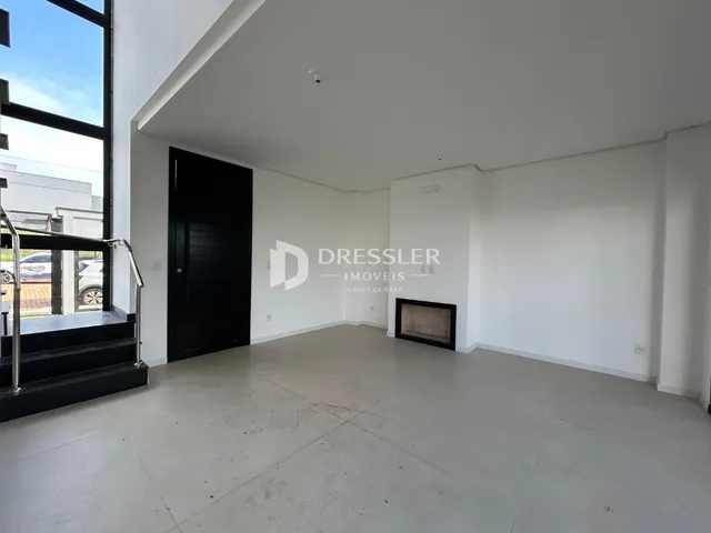 Sala de estar com paredes brancas e piso de concreto.