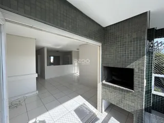 Vista de um corredor interno com piso de cerâmica e paredes revestidas de azulejos na propriedade.