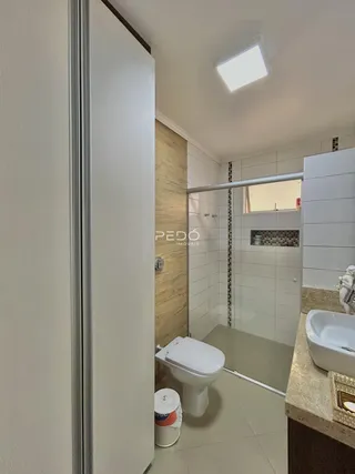 Foto de um banheiro moderno com box de vidro e piso cerâmico.