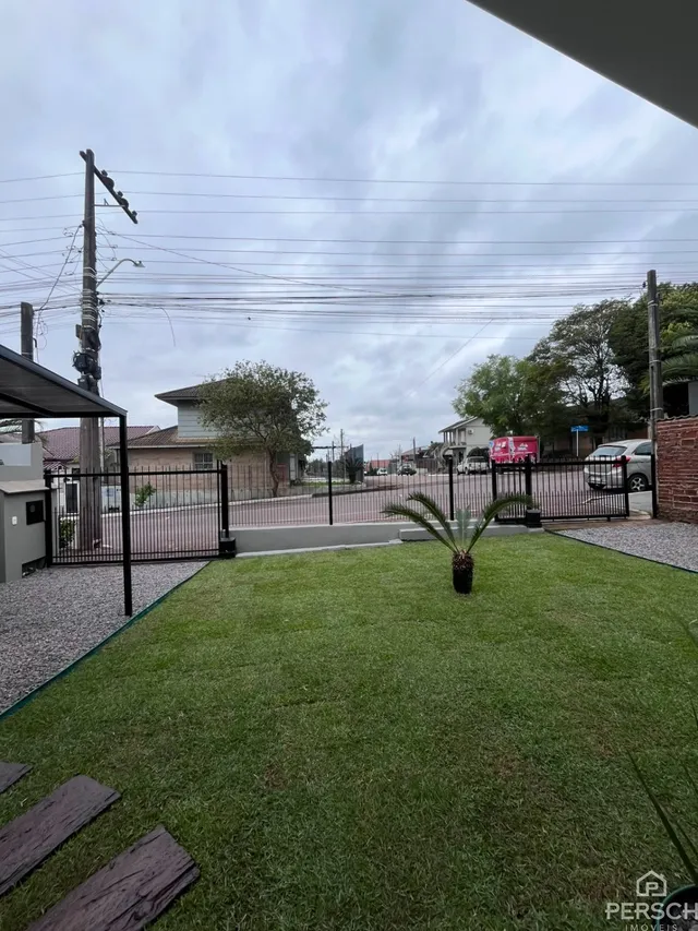 Foto de uma área gramada em frente a uma residência.