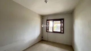 Vista interna de um cômodo com paredes brancas e piso de cerâmica.