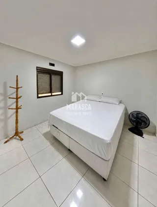 Quarto com cama e piso de cerâmica branca.
