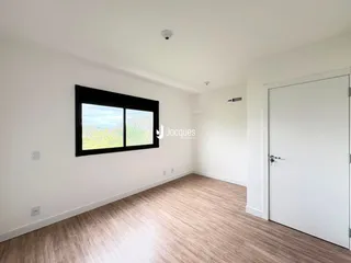 Uma sala de estar com piso de madeira clara e janela.