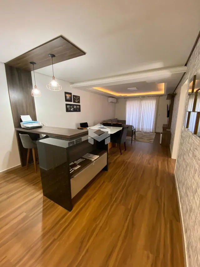 Ambiente interno com piso de madeira e painel de madeira na sala.