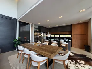 Vista de uma sala de jantar com mesa de madeira e cadeiras em um imóvel no Brasil.