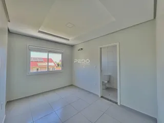 Ambiente interno de uma sala com piso de cerâmica e porta de banheiro.