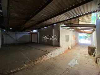 Imagem de um espaço interno com piso de concreto aparente e estrutura exposta.