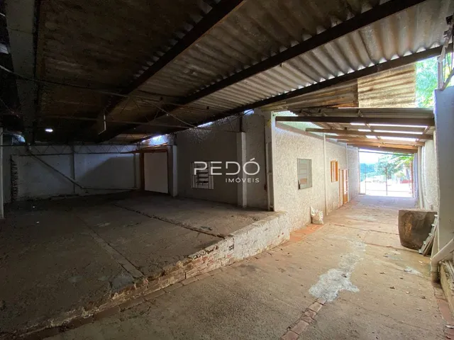 Imagem de um espaço interno com piso de concreto aparente e estrutura exposta.