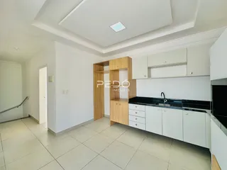 Cozinha moderna com armários brancos e detalhes em madeira.