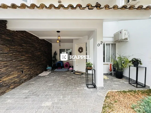 Vista da área externa com piso de pedra e parede texturizada de uma residência.