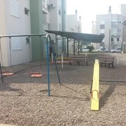 Área externa com piso de cascalho e bancos de madeira.