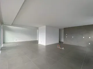 Ambiente interno amplo com piso de porcelanato cinza e paredes brancas.