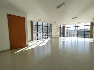 A sala de estar possui piso claro e grandes janelas.