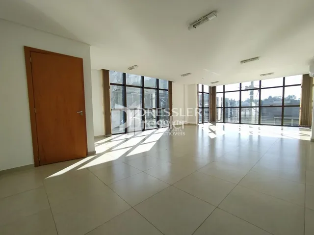 A sala de estar possui piso claro e grandes janelas.