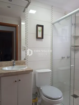 Foto de um banheiro interno com azulejos brancos e box de vidro.
