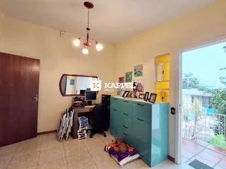 Sala de estar com armário azul e área de trabalho.