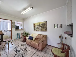 Sala de estar com sofá e pintura na parede de uma residência.