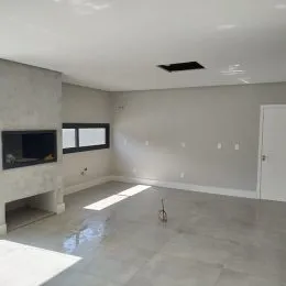 Foto de um ambiente interno com paredes brancas e piso de concreto.