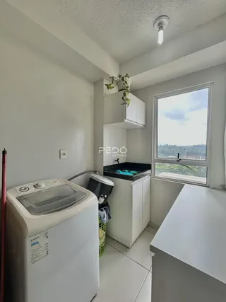 Foto de uma área interna com máquina de lavar roupa e janela.