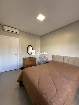 Um quarto com cama grande e cômoda de madeira é mostrado na sala.
