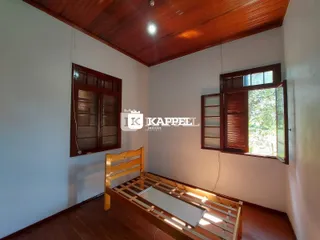 Quarto com cama de madeira e piso de madeira.