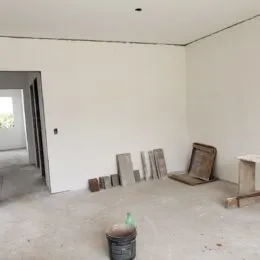 Foto de um cômodo interno com paredes brancas e piso de concreto.