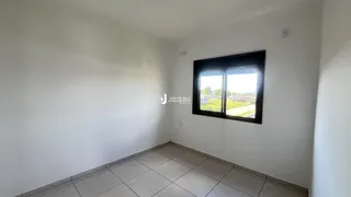 Vista interna de um cômodo com piso de cerâmica e janela.