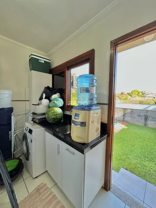 Cozinha com janela que dá acesso a um quintal gramado.