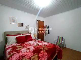 Quarto com cama decorada em tons de vermelho e rosa.