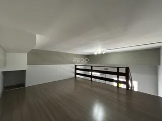 Sala de estar com piso de madeira e parede de madeira em um imóvel no Brasil.