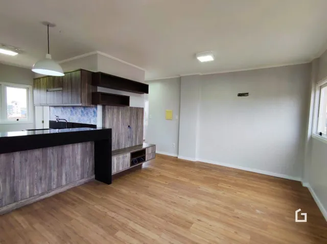 Ambiente interno com piso de madeira e armários de cozinha.