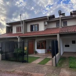 Fachada de uma residência em Lajeado, Brasil, com telhado de telhas e cerca de metal.
