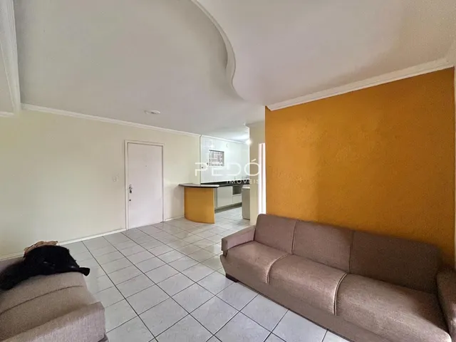 Sala de estar com sofá e piso de cerâmica em um imóvel no Brasil.