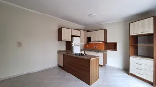 Foto de uma cozinha com armários de madeira e piso claro.