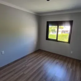 Foto de um cômodo com piso de madeira e uma janela.