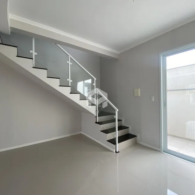 Hall com escadaria moderna e paredes cinzas claras.