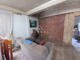 Sala de estar com sofá e parede de tijolos aparentes.