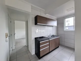 A cozinha apresenta armários de madeira e piso cerâmico.