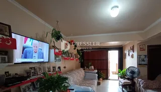 Sala de estar com sofá e televisão em um imóvel no Brasil.