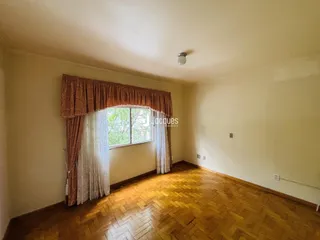 Foto de uma sala com piso de madeira e janela decorada.
