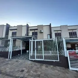 Vista externa de uma propriedade com cerca e portão metálico.